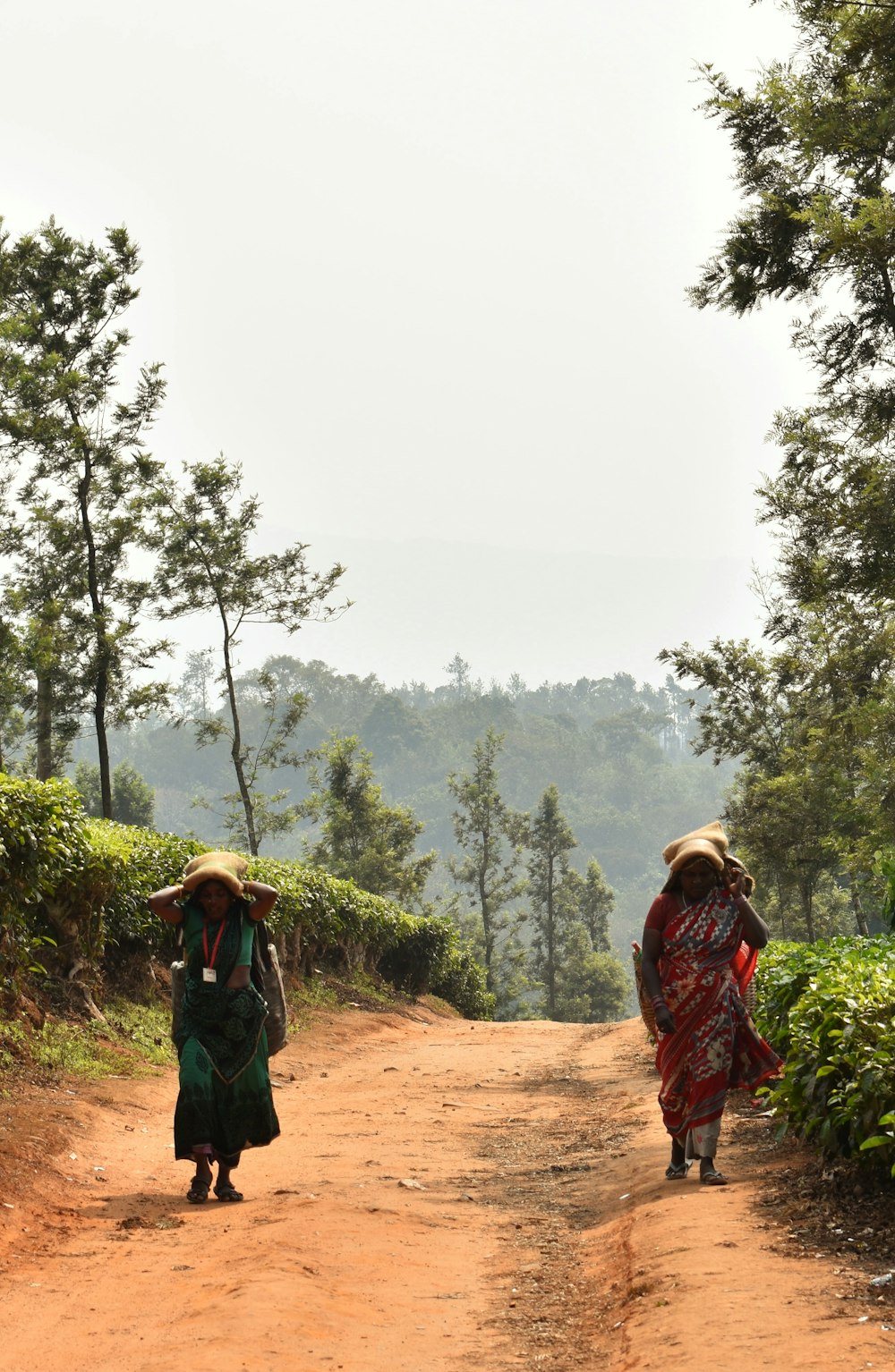 woman in green and brown dress standing on brown dirt road during daytime