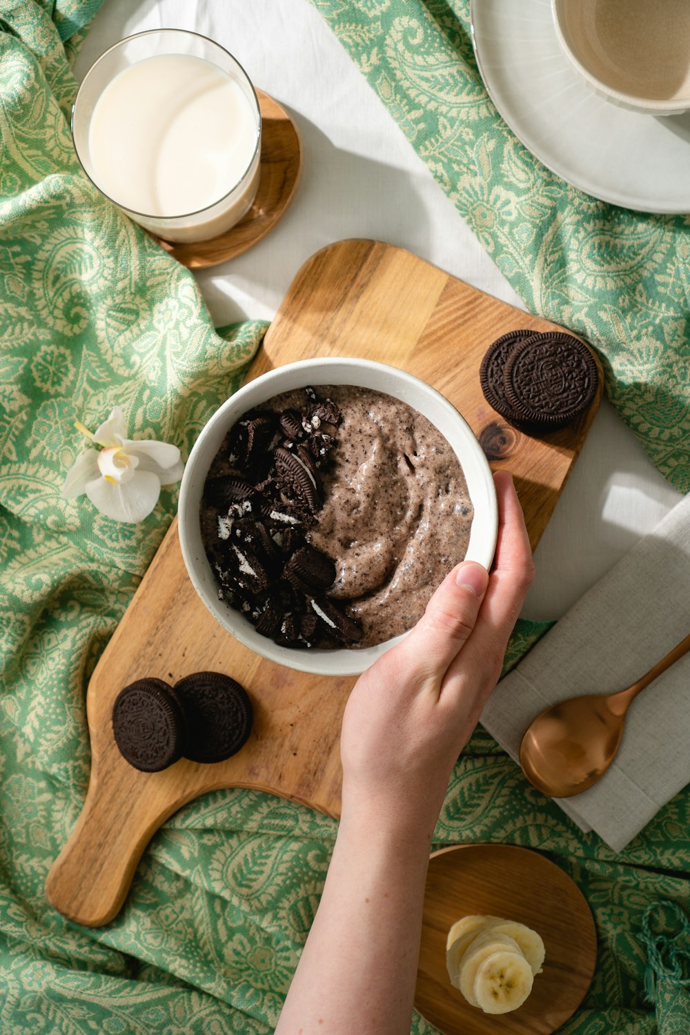 person holding white ceramic bowl with chocolate ice cream