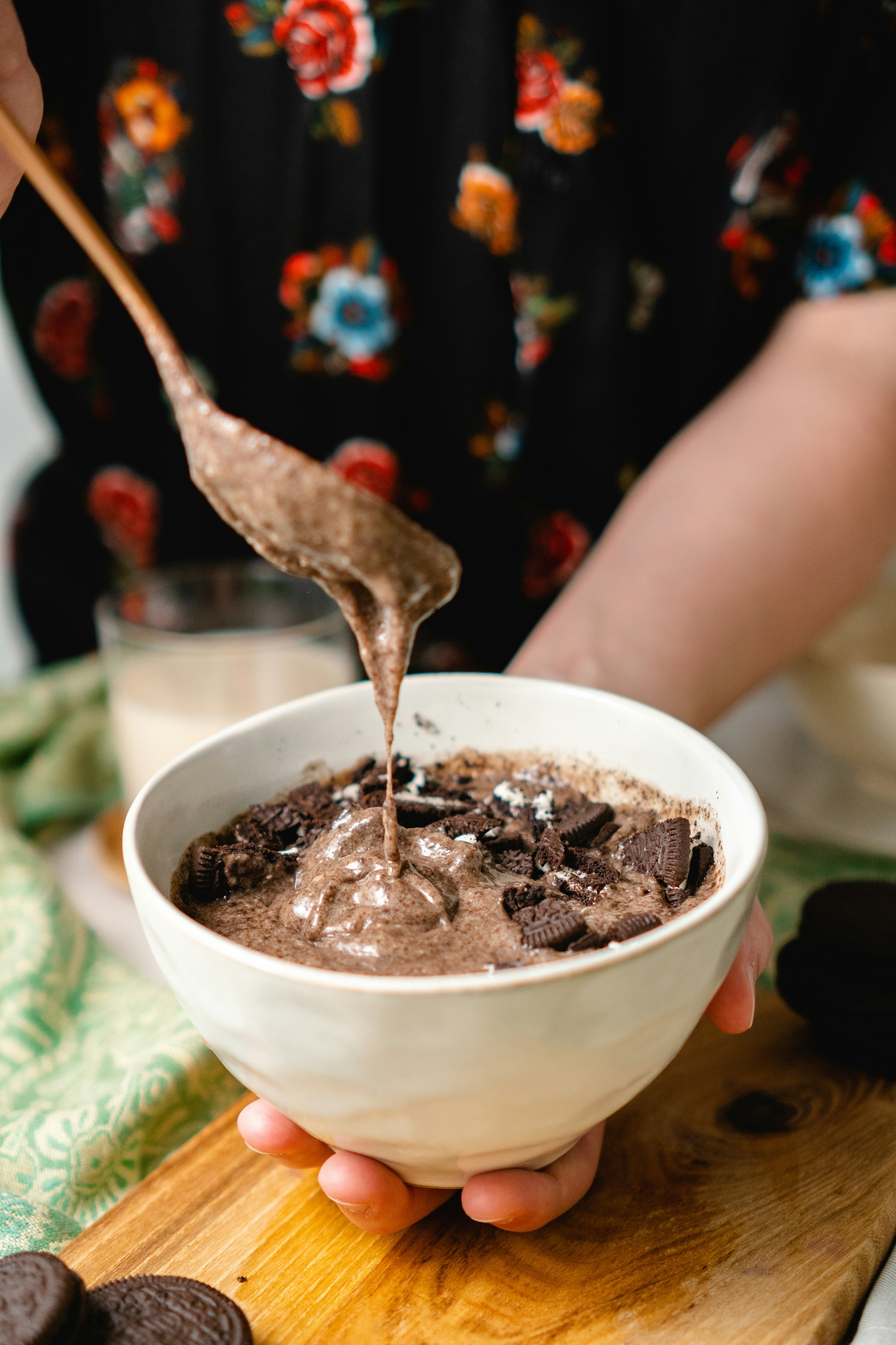 person holding white ceramic bowl with brown liquid