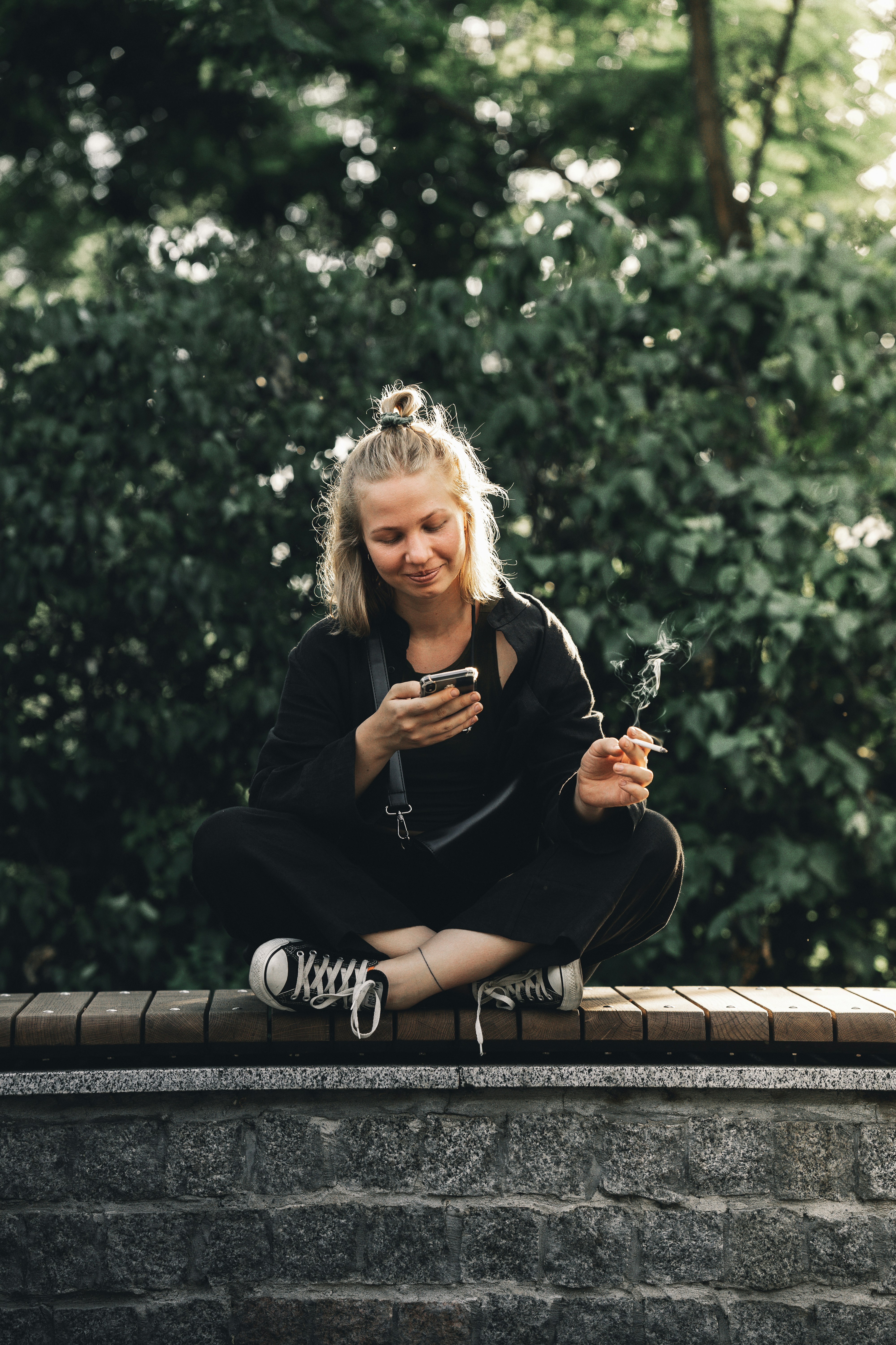 Frau im schwarzen Langarmhemd sitzt auf brauner Holzbank