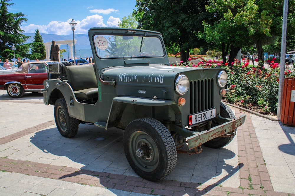 green and black jeep wrangler parked on gray concrete pavement during daytime