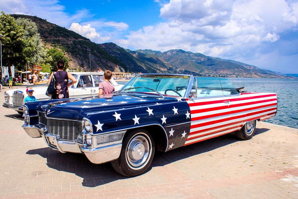 people riding red and white vintage car during daytime