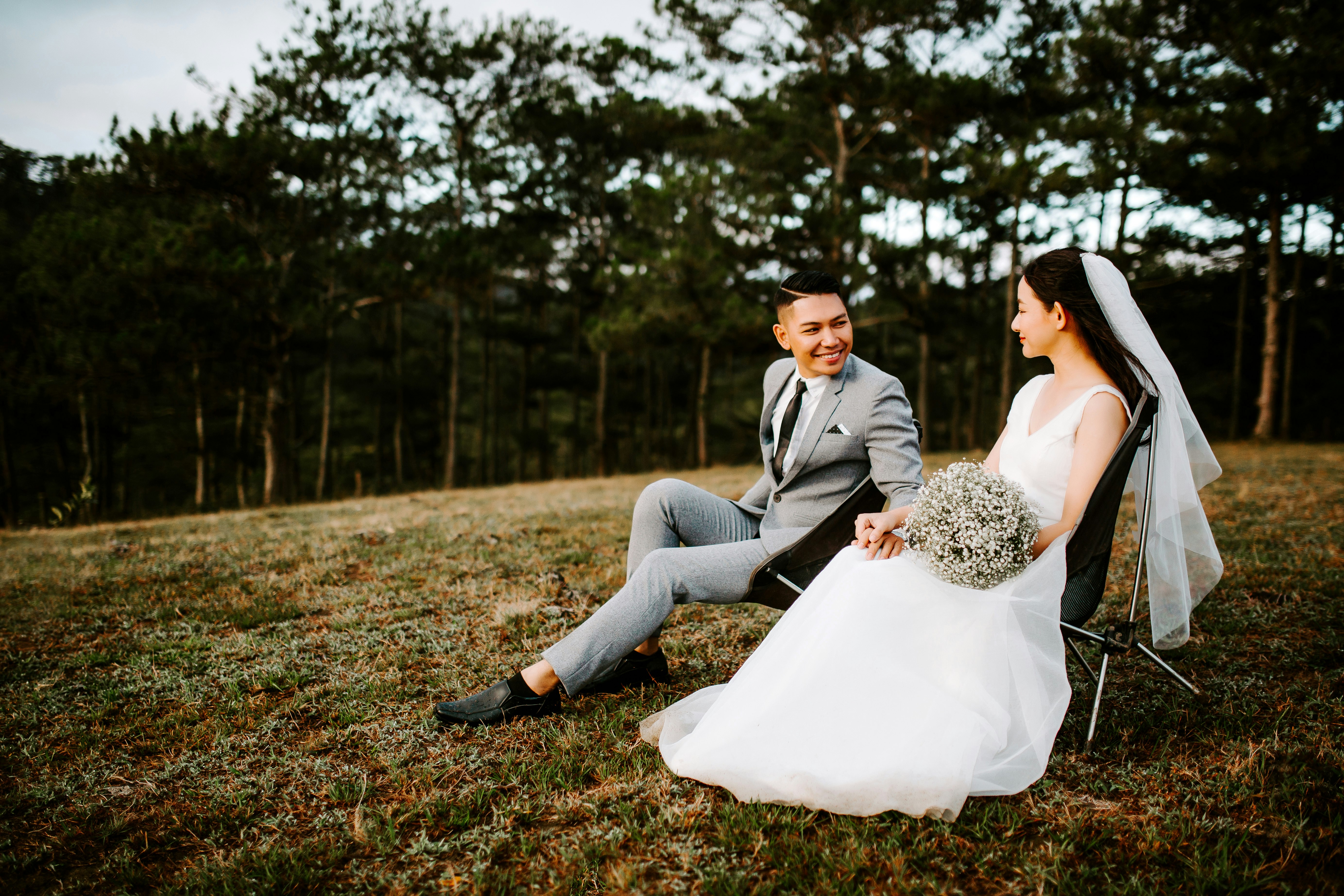 man and woman sitting on grass field during daytime