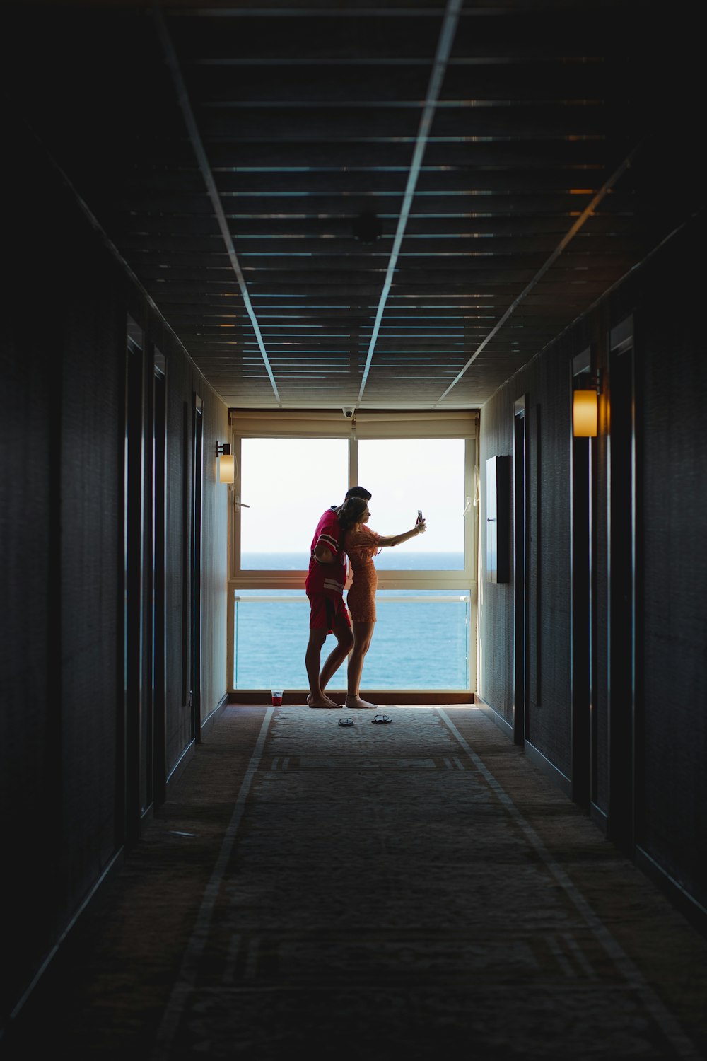 woman in red dress walking on hallway