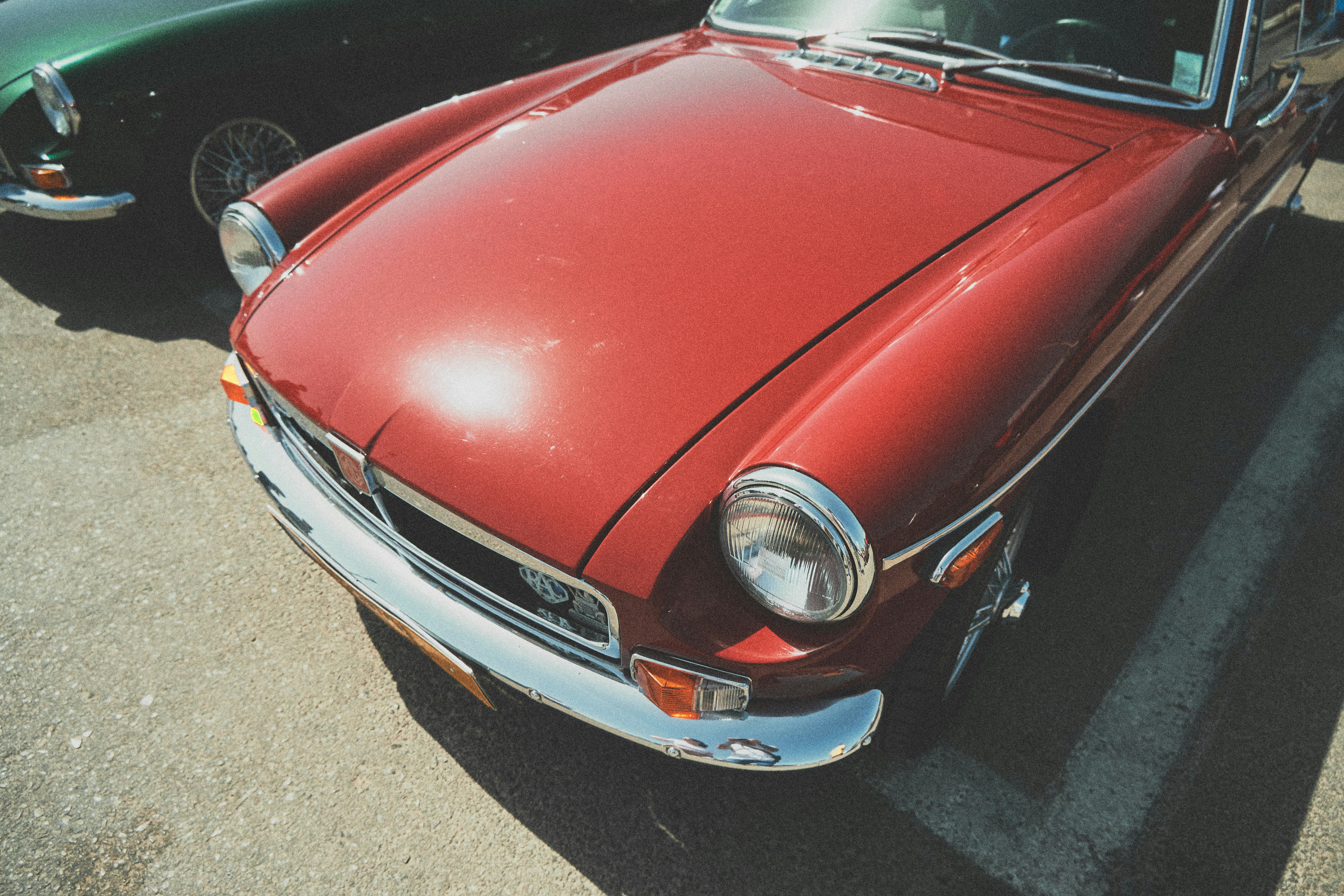 red car on gray asphalt road during daytime