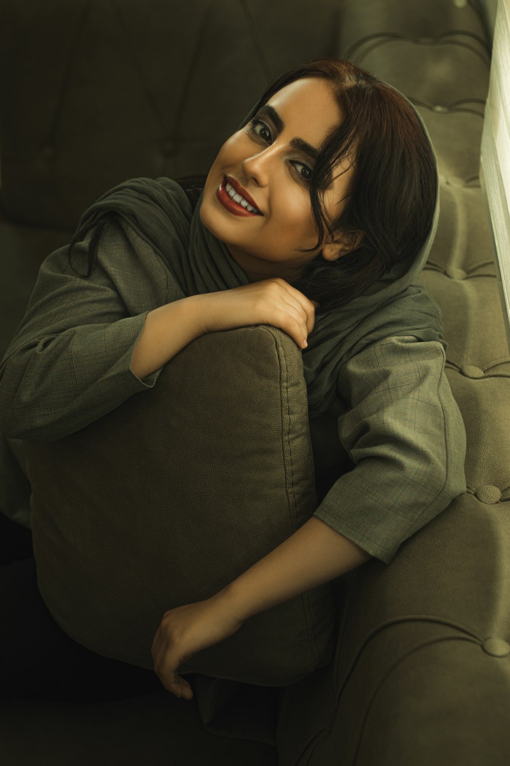 woman in gray long sleeve shirt lying on bed