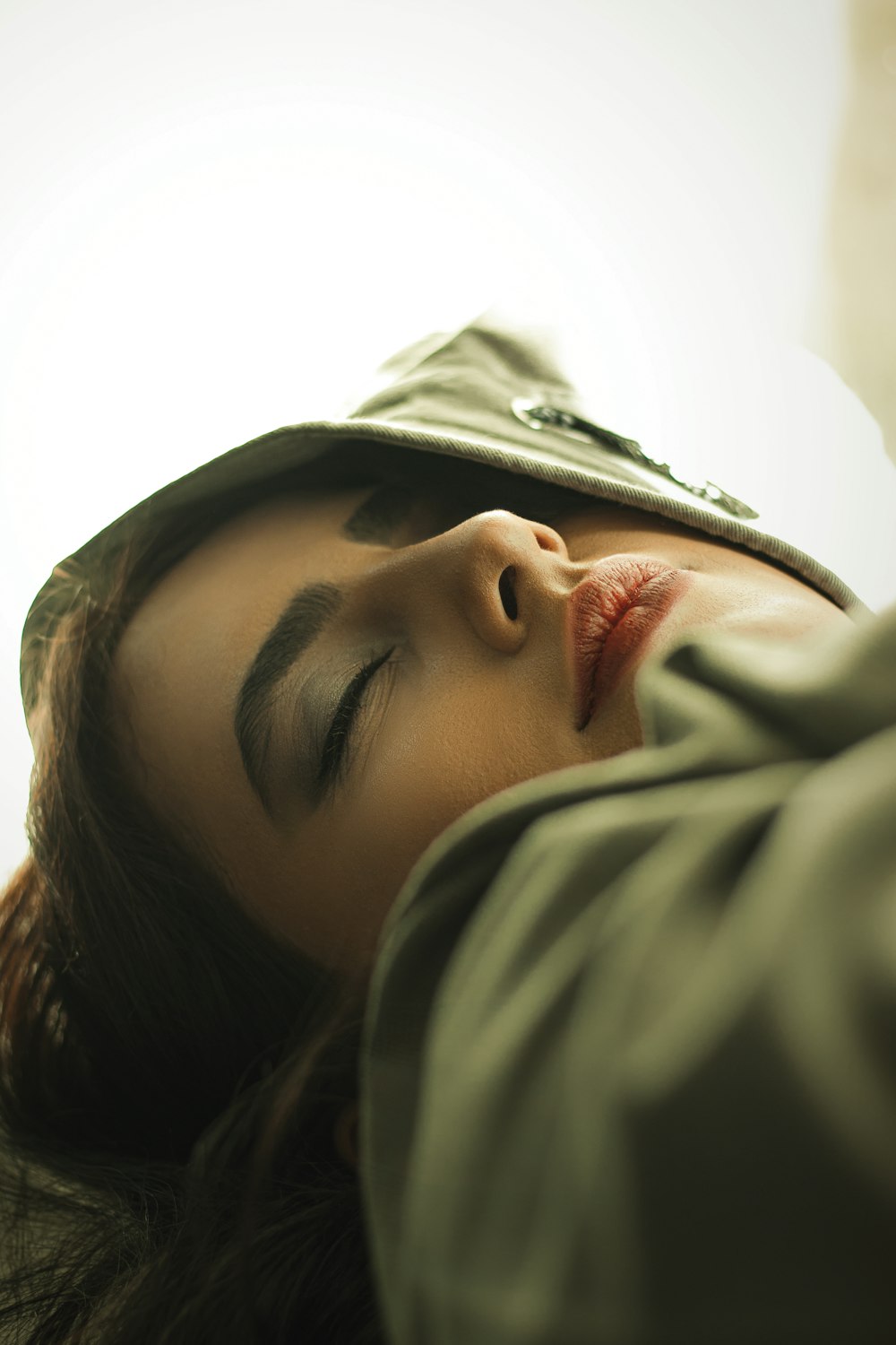 woman in gray hoodie covering her face with gray textile