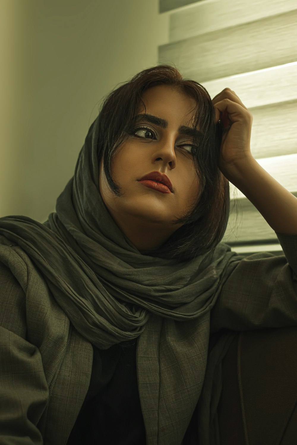 femme en hijab gris assis sur un canapé gris