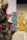 Intricately designed glass sculptures with vibrant colors are displayed on pedestals. The foreground features a dark sculpture with red and translucent spikes. In the background, blue and yellow glass sculptures add contrast and depth.
