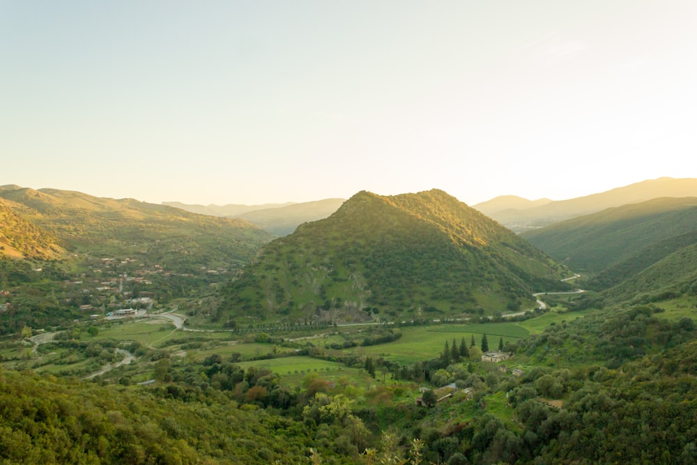 Montañas verdes bajo el cielo blanco durante el día