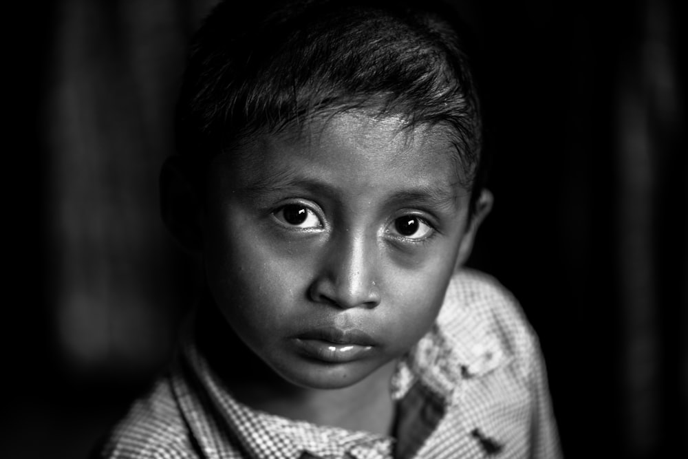 grayscale photo of boy in checked shirt