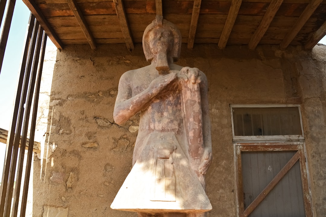 man holding a book statue