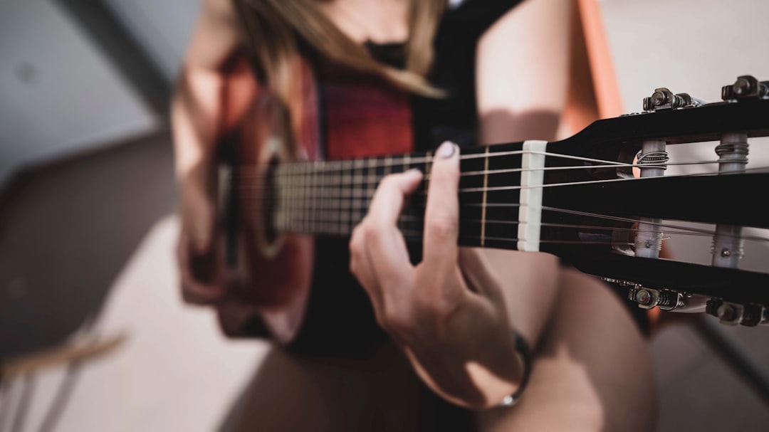 woman playing acoustic guitar in close up photography