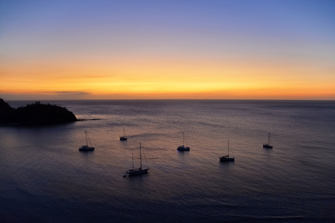 silhouette of boat on sea during sunset