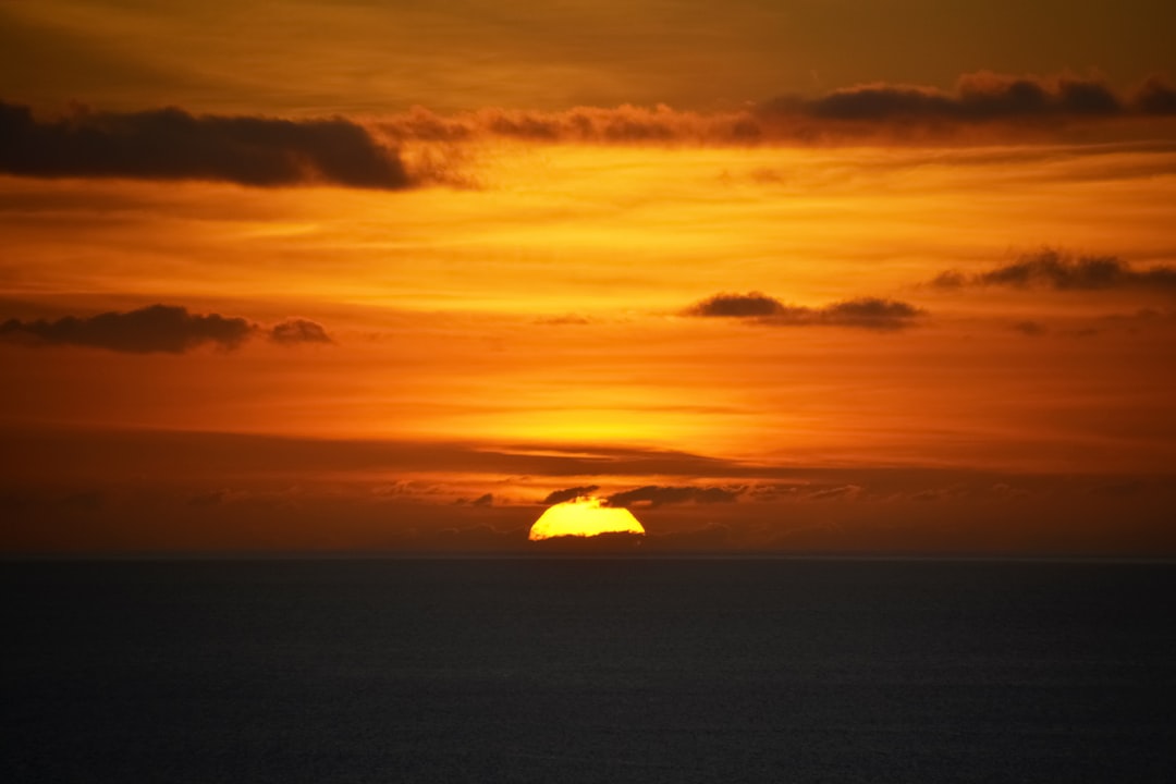 body of water under cloudy sky during sunset