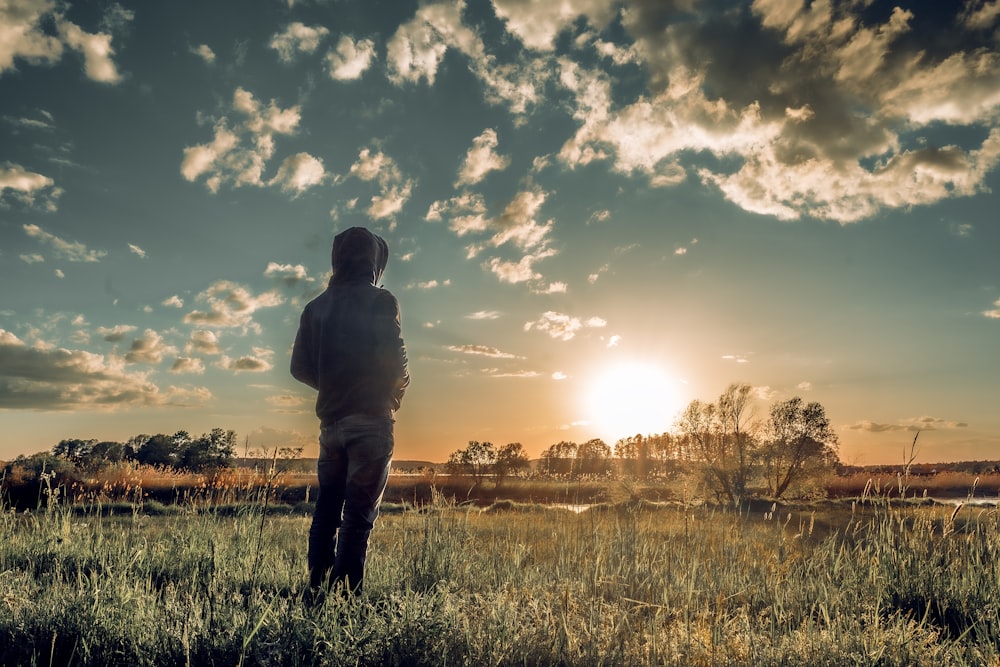 man and woman kissing on green grass field during sunset