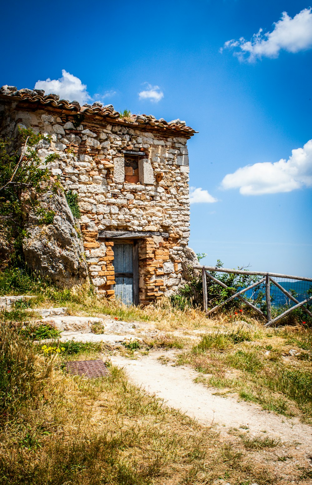 brown brick house near body of water under blue sky during daytime