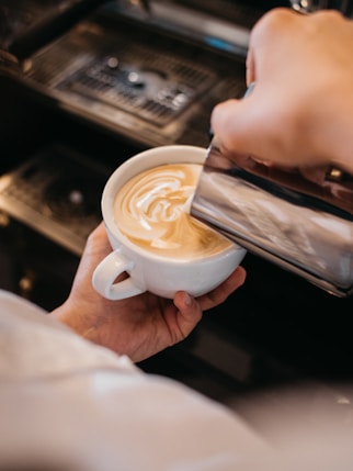 person holding white ceramic mug with coffee