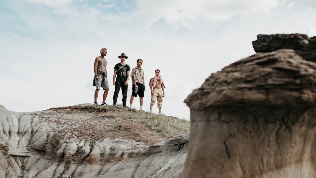 group of people standing on rock formation during daytime