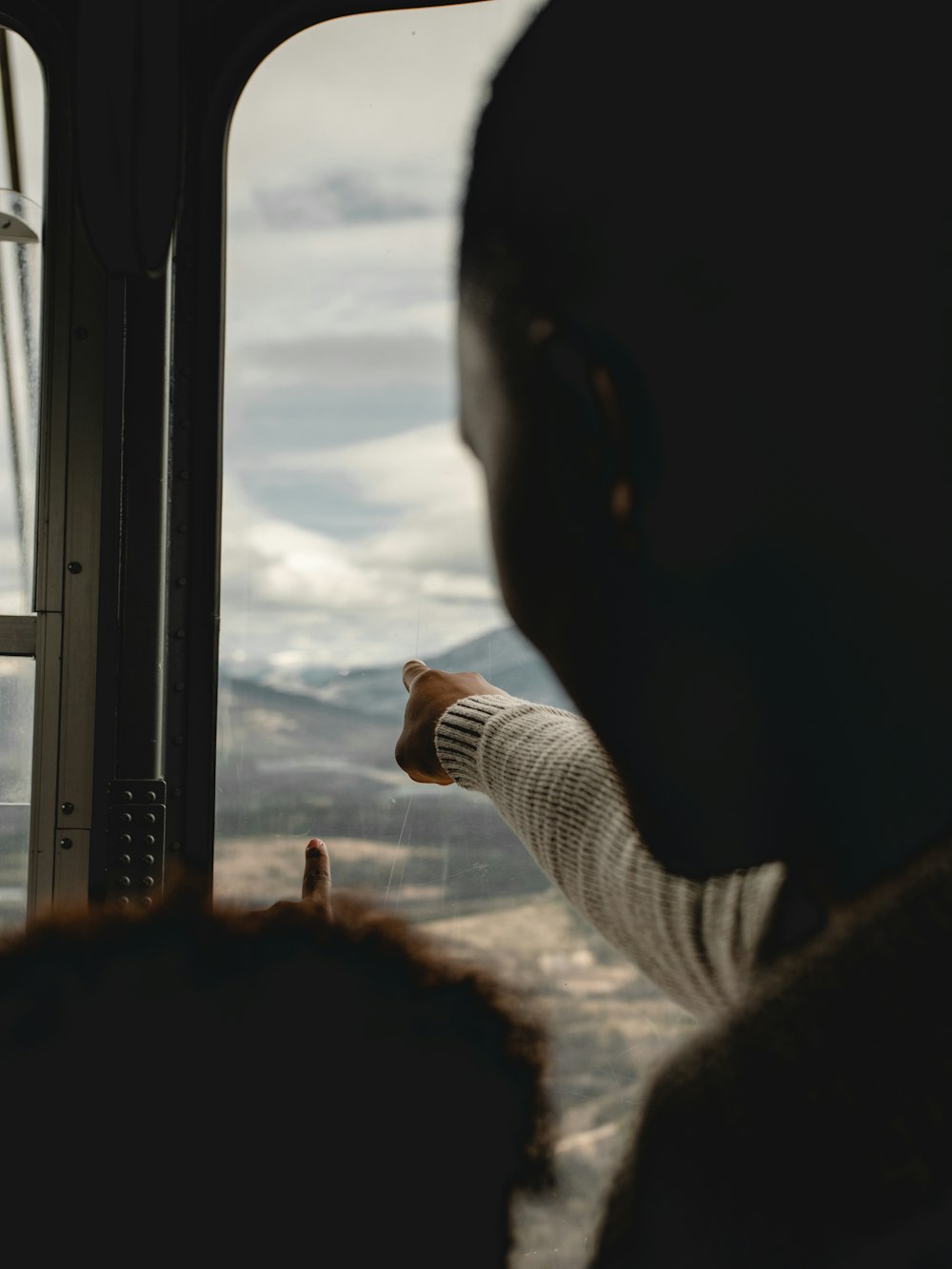 person in white long sleeve shirt holding glass window during daytime