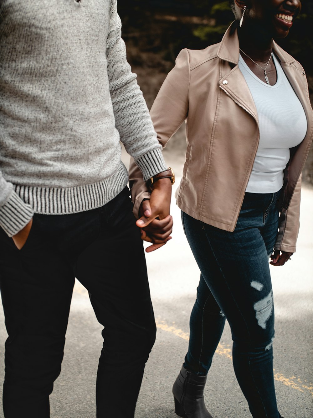 man in gray sweater and blue denim jeans holding hands with woman in gray sweater