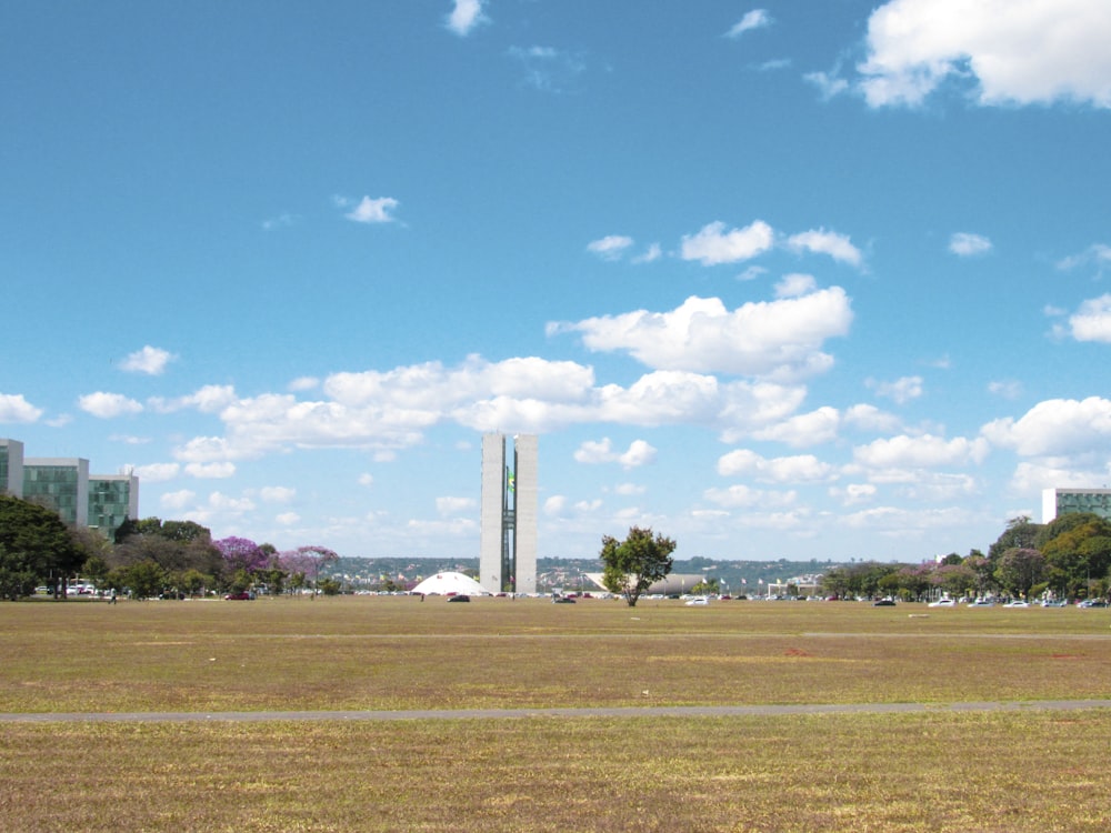 green grass field under blue sky and white clouds during daytime