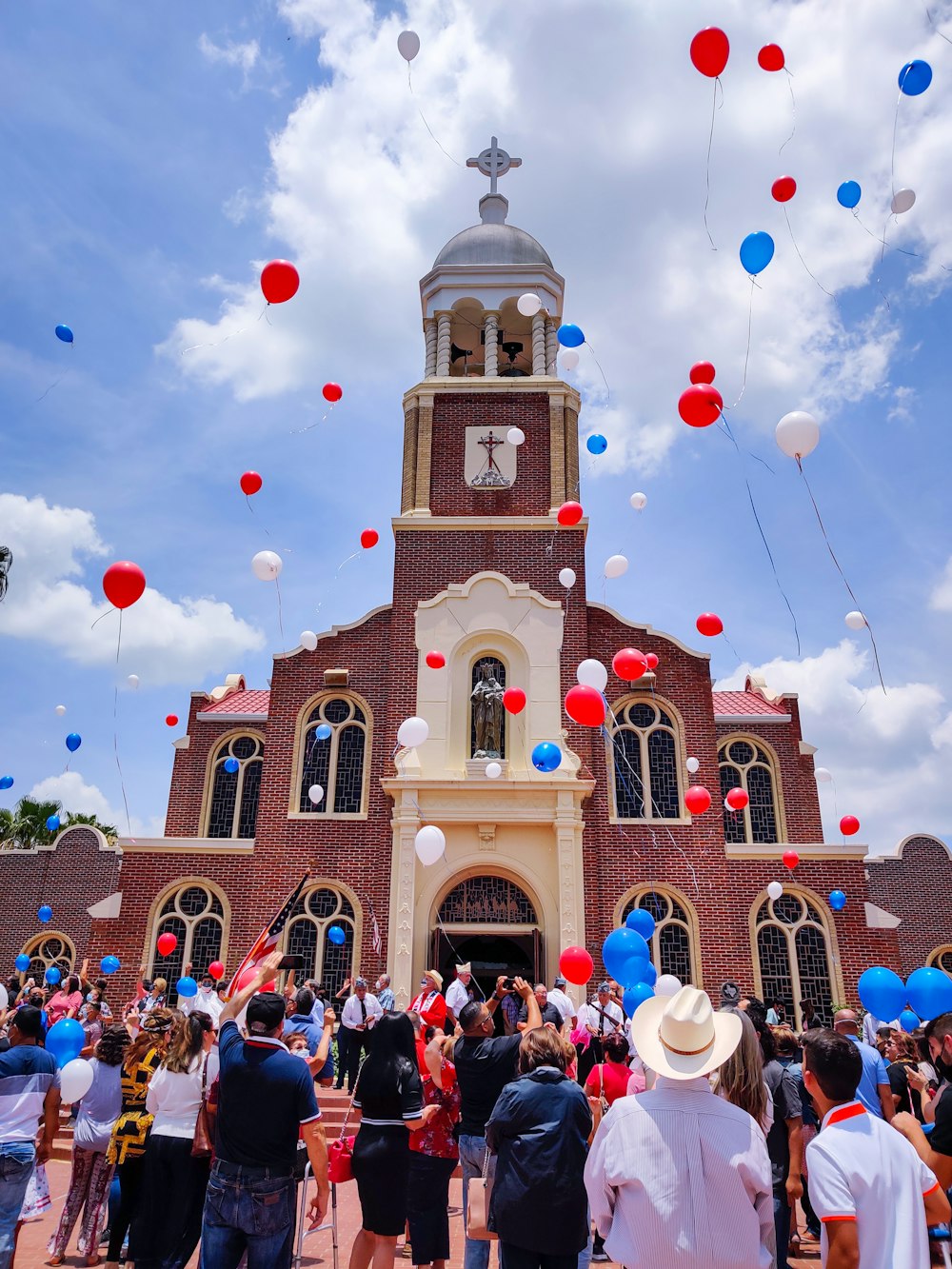 pessoas na frente da catedral marrom e branca sob o céu nublado durante o dia