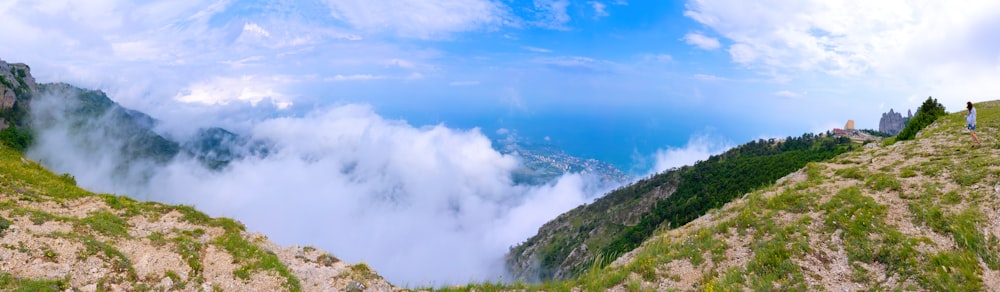 green grass covered mountain under white clouds and blue sky during daytime