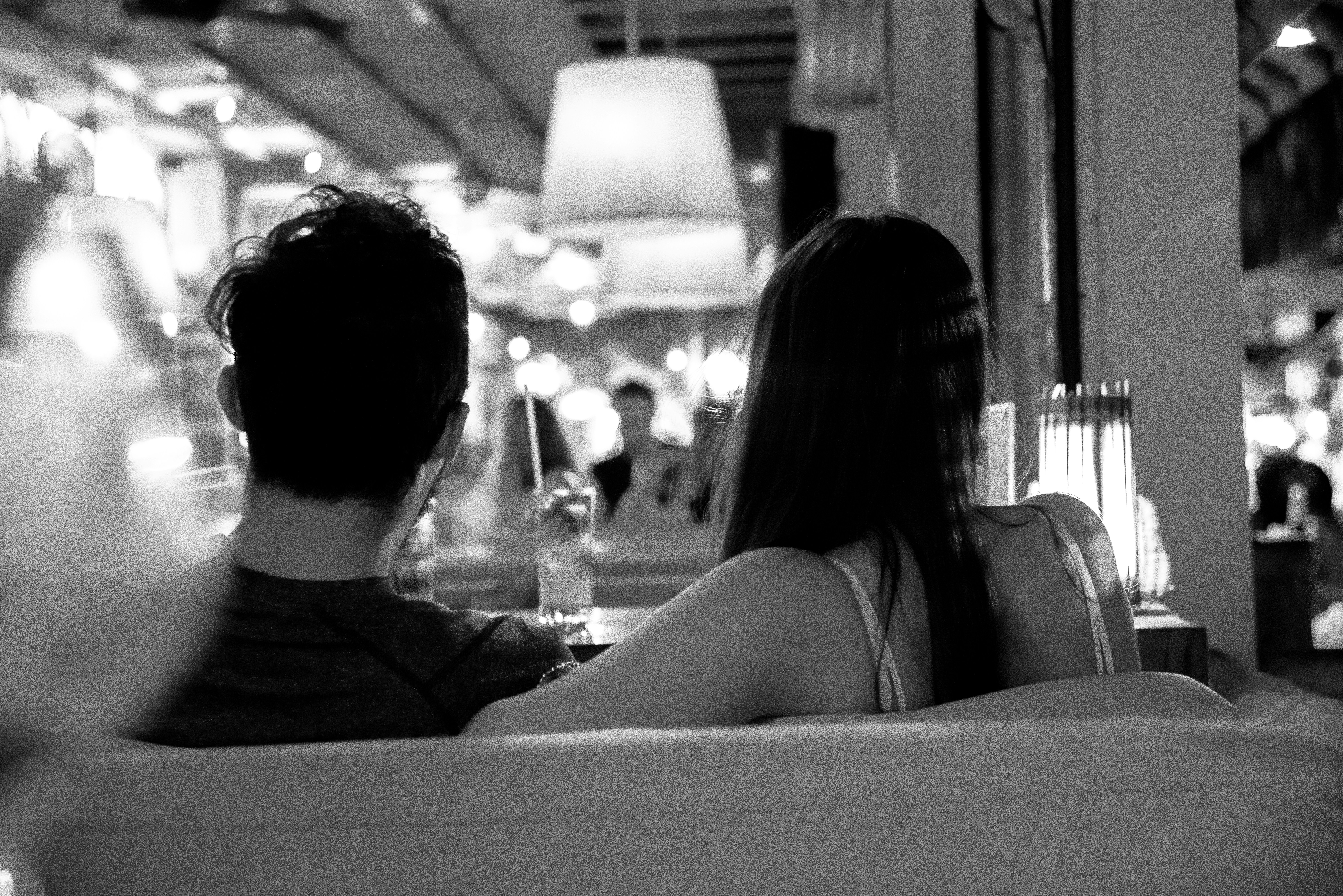 grayscale photo of couple sitting on chair