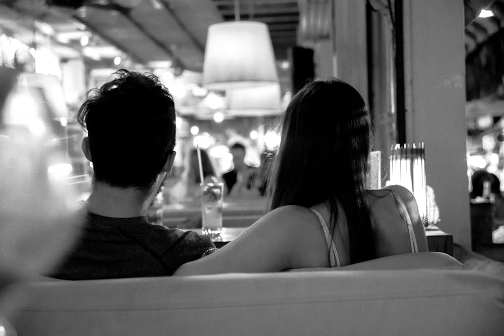grayscale photo of couple sitting on chair