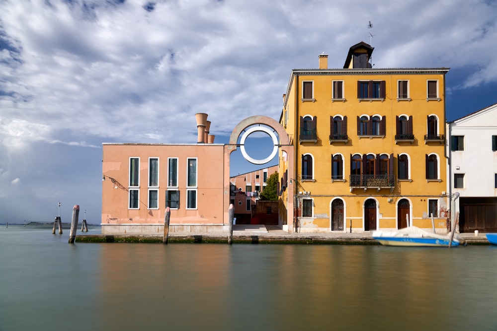 brown concrete building beside river during daytime