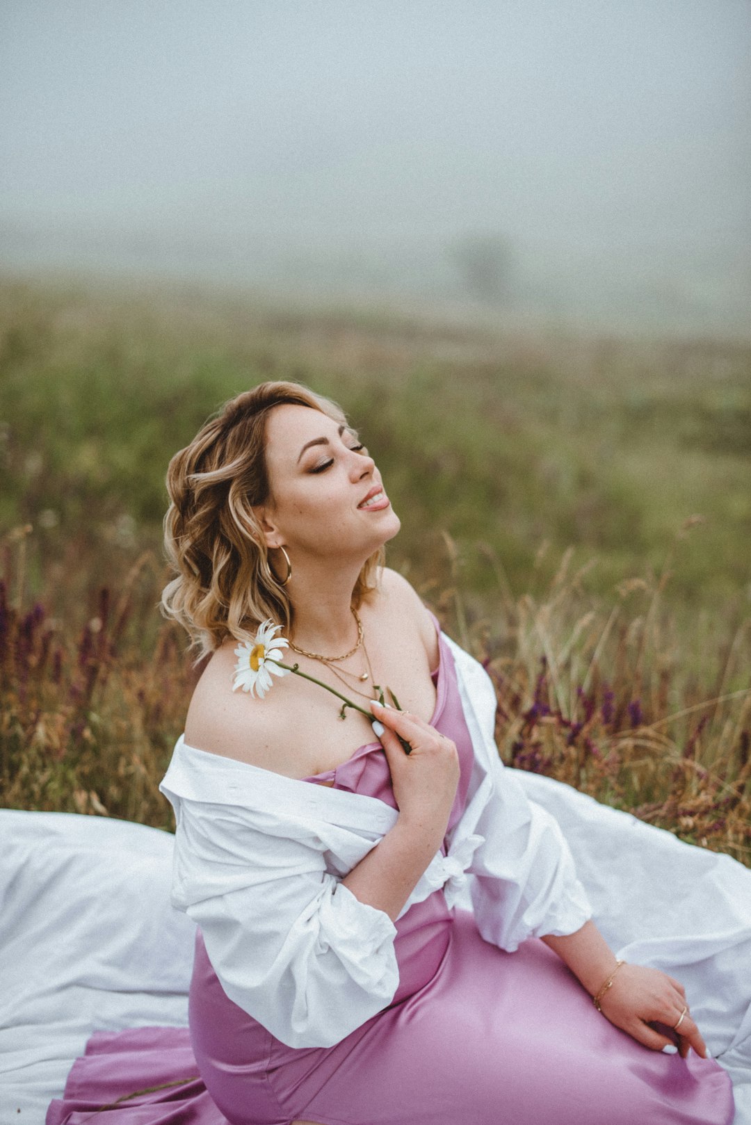 woman in white dress lying on grass field during daytime