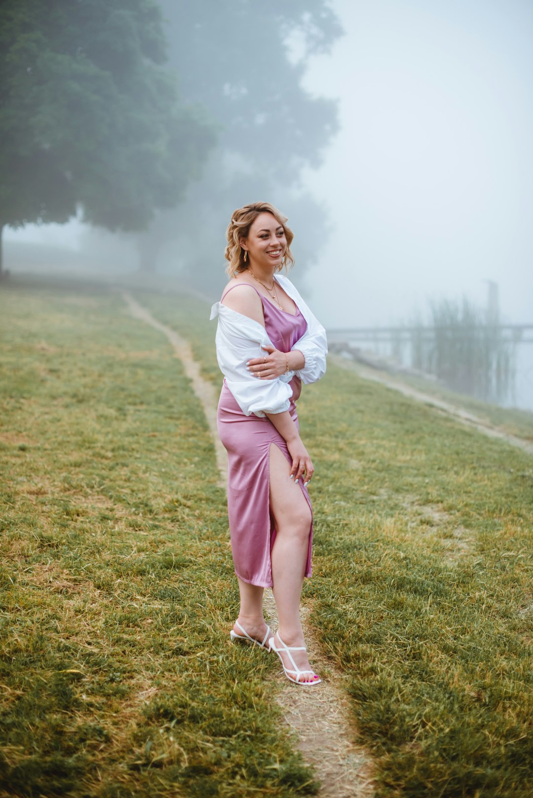 woman in white long sleeve shirt and pink pants standing on green grass field during daytime