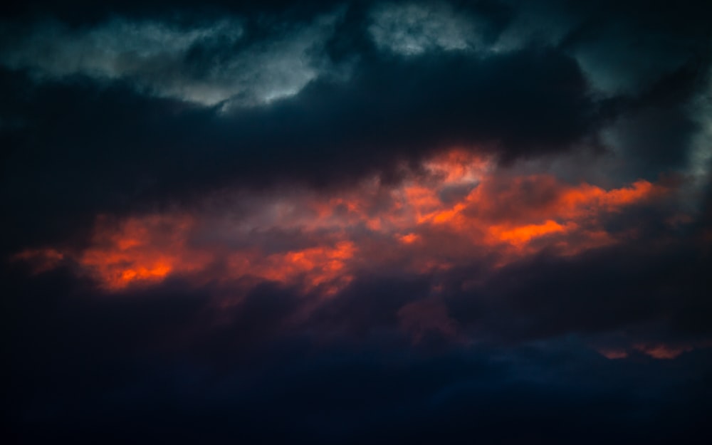 밤 시간 동안 검은 색과 주황색 구름
