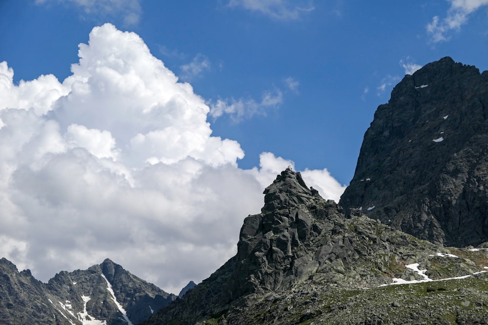 rocky mountain under white clouds and blue sky during daytime