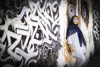 woman in blue and white long sleeve dress standing beside white and black wall