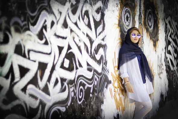 woman in blue and white long sleeve dress standing beside white and black wall