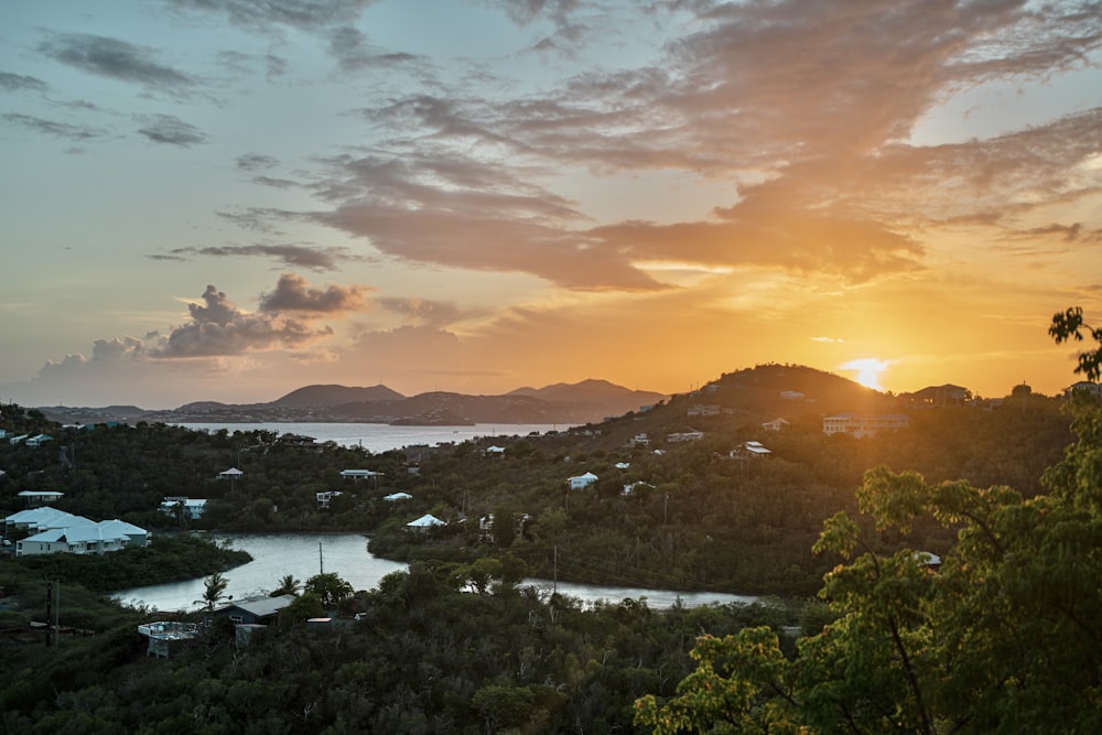 green trees and mountains during sunset