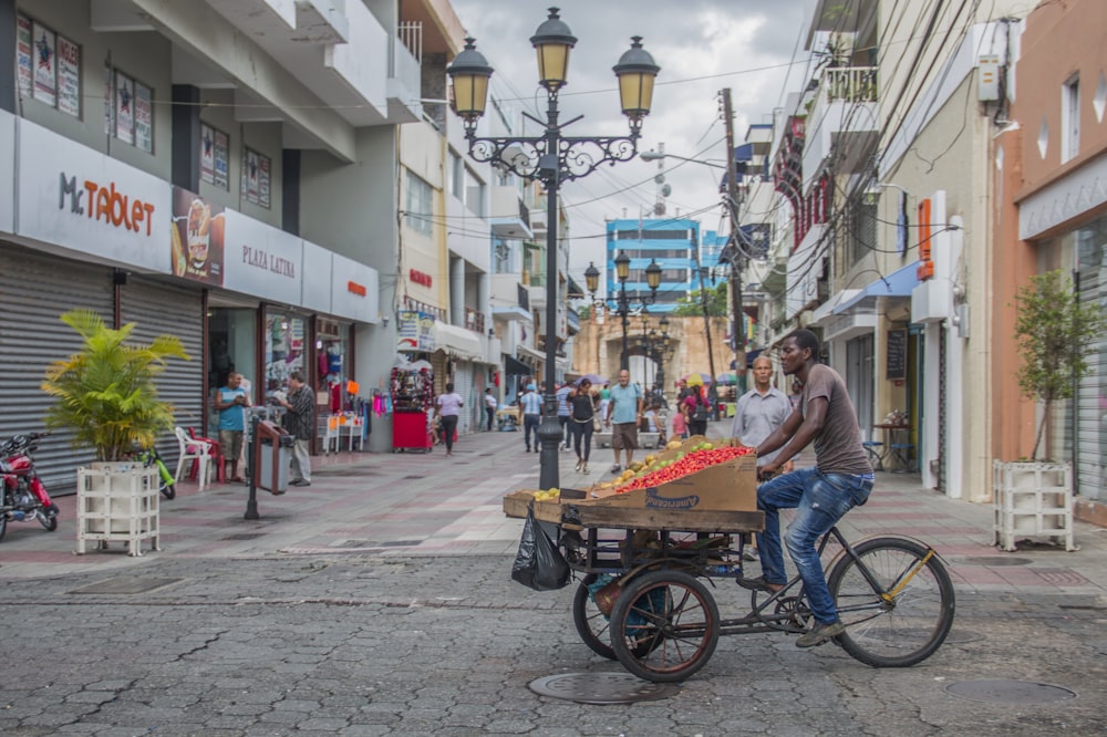 man in blue shirt riding on brown and black trike on street during daytime