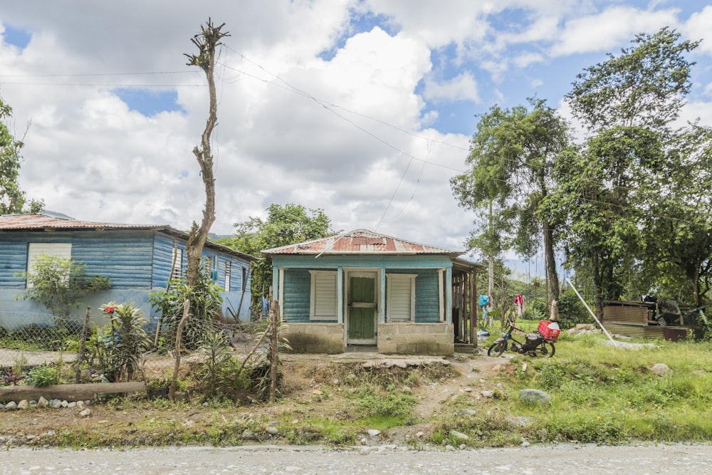 blue and brown wooden house near green trees under blue sky during daytime