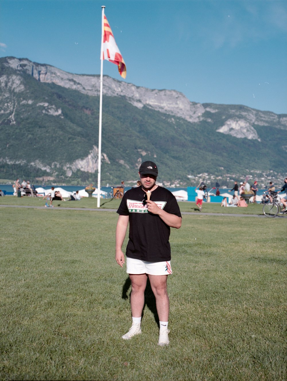 woman in black shirt and white shorts standing on green grass field during daytime