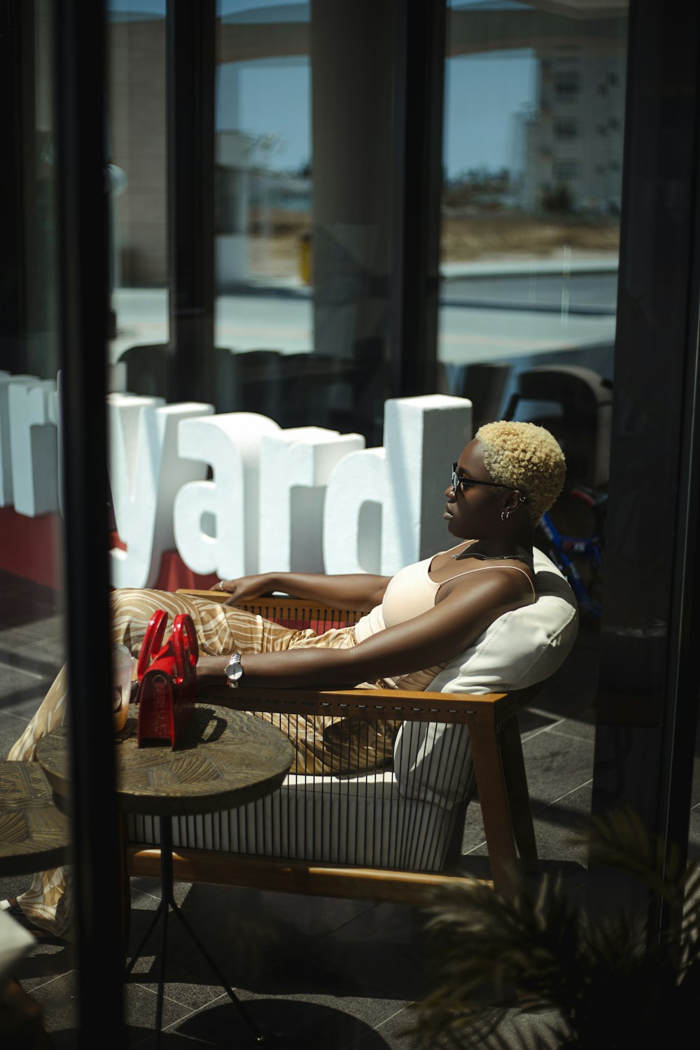 woman in black tank top sitting on brown wooden chair