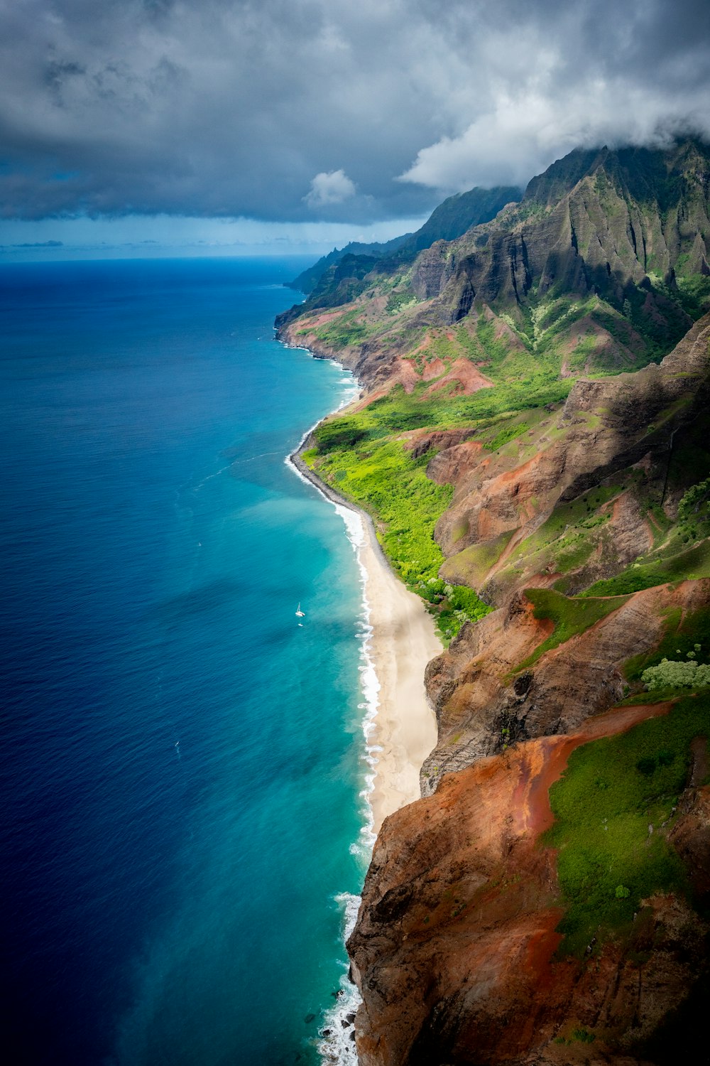 vista aérea da montanha verde e marrom ao lado do mar azul durante o dia