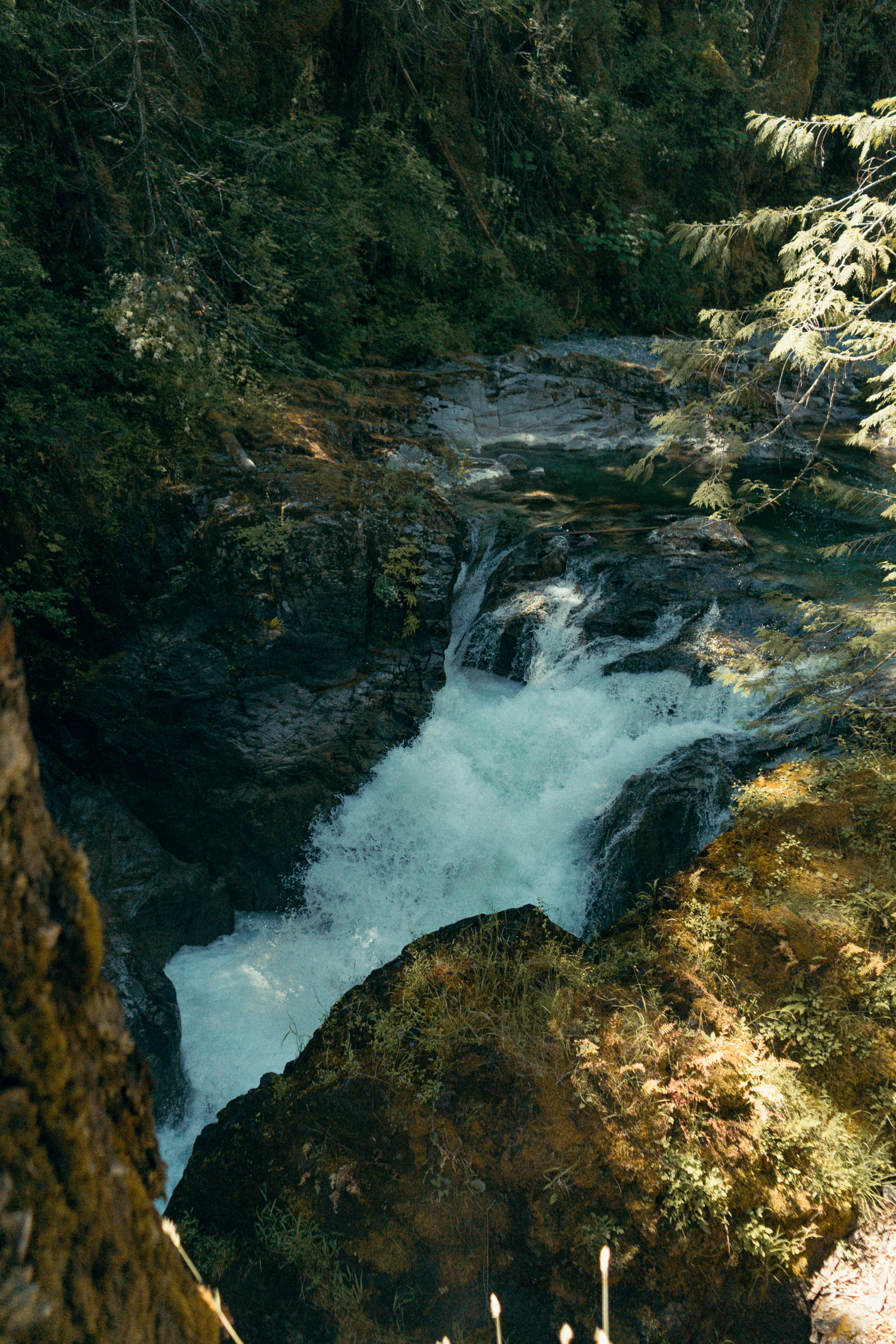 water falls between brown rocks