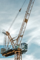 orange and gray crane under cloudy sky during daytime