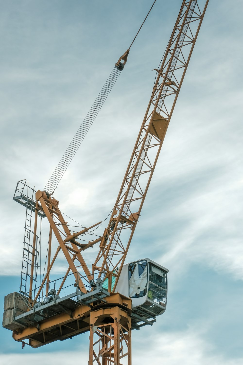 orange and gray crane under cloudy sky during daytime
