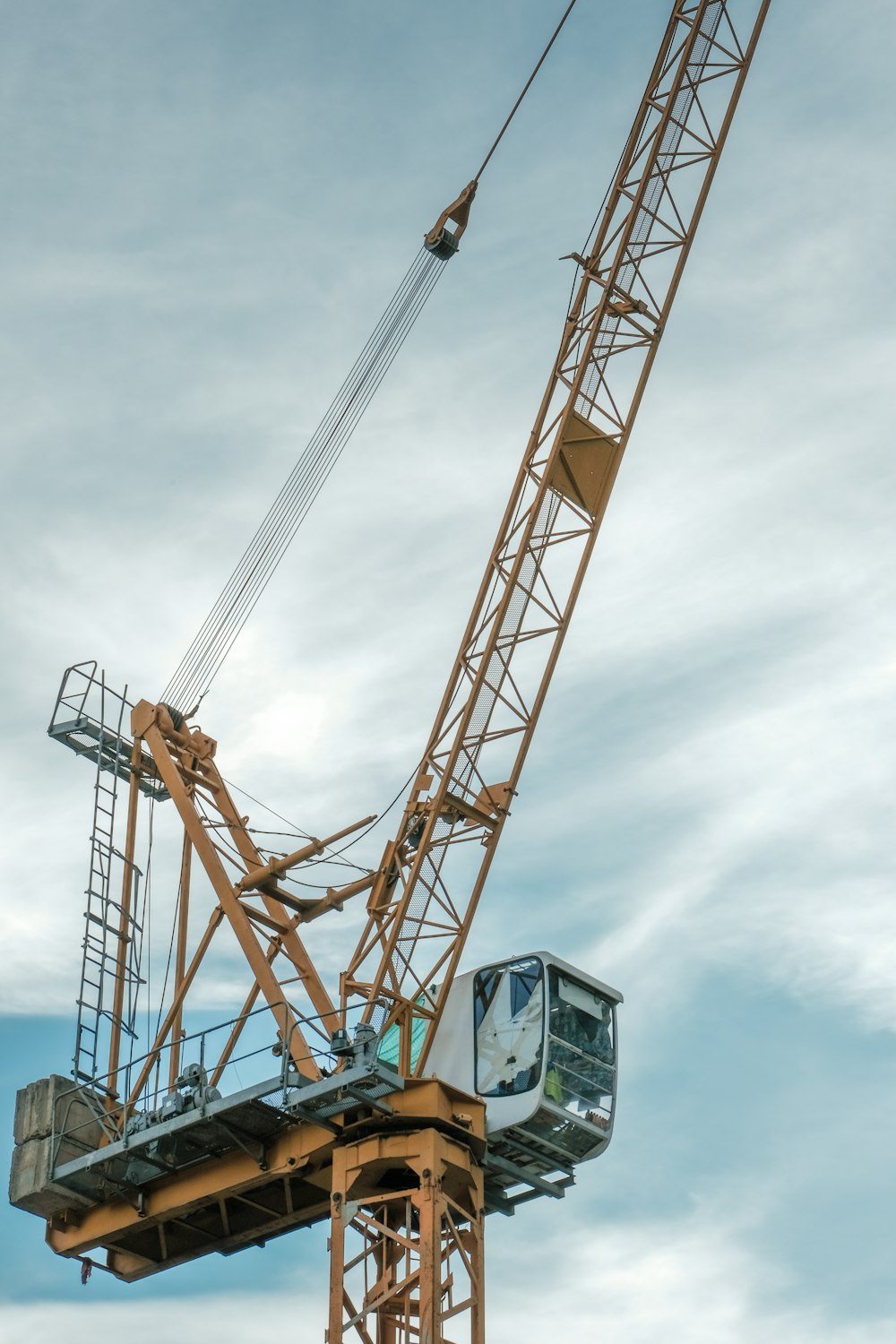 grue orange et grise sous ciel nuageux pendant la journée