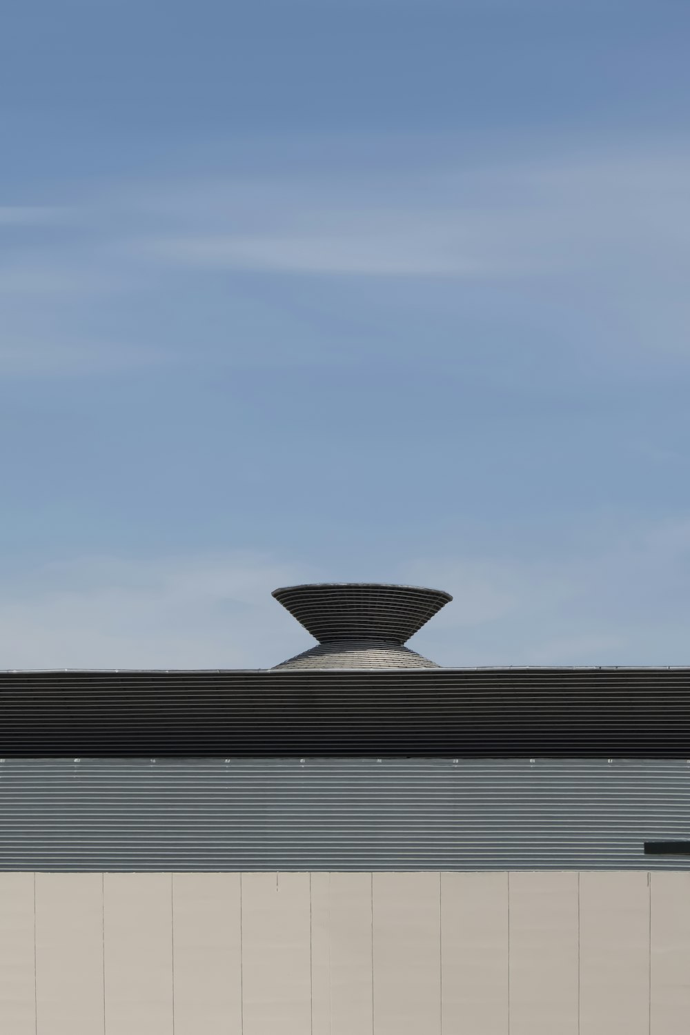 gray and white striped building under blue sky during daytime