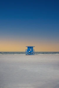 blue wooden lifeguard house on beach during daytime