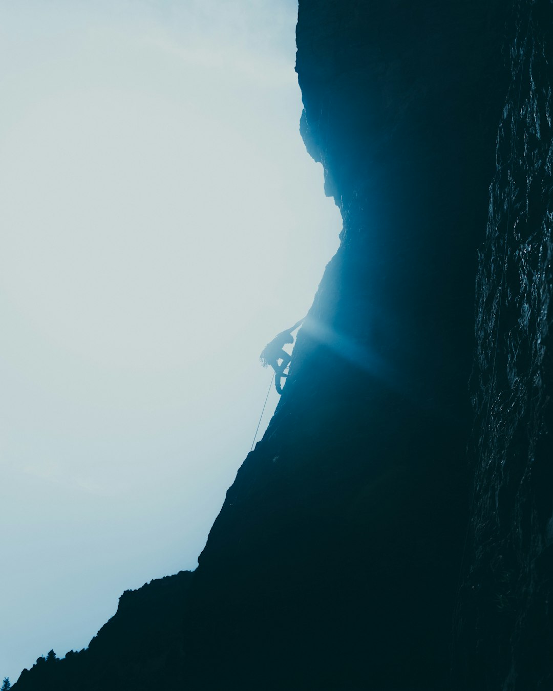 man in black jacket standing on rock formation during daytime